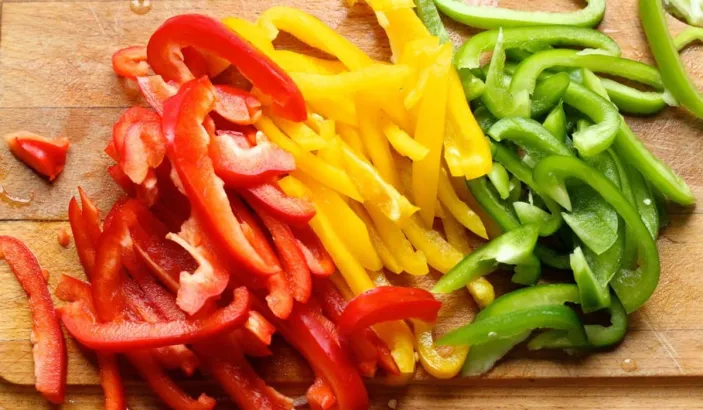 Poivrons rouge, jaune et vert coupés en morceaux