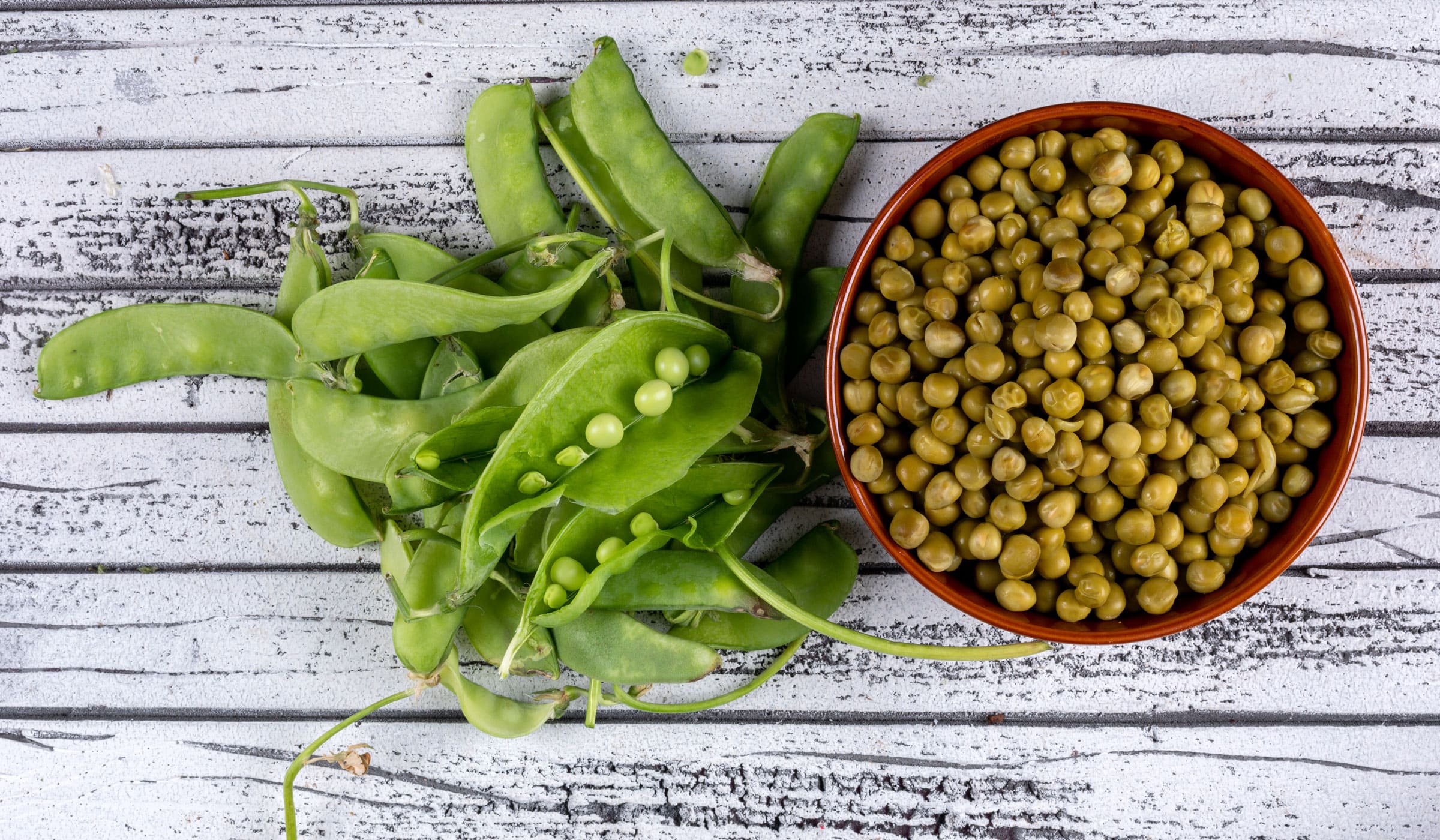 Cooked pigeon peas in a bowl and freshly picked pigeon peas