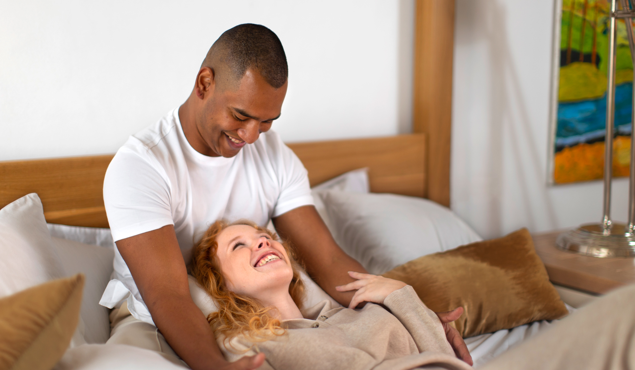 Couple couché dans un lit partageant un regard complice