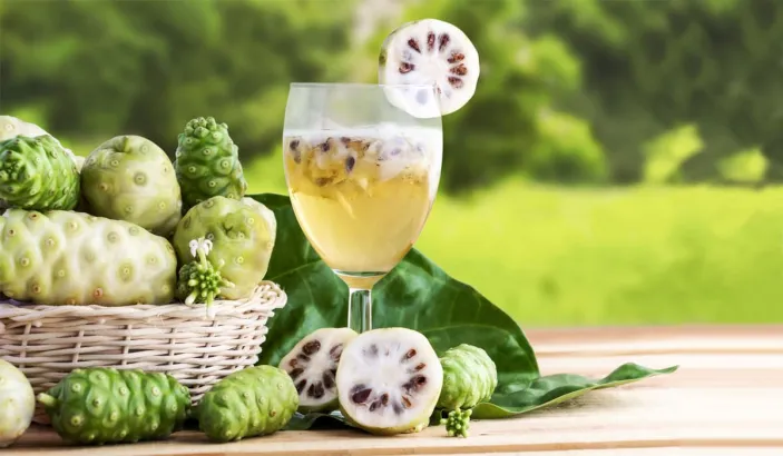 Basket of noni fruit with noni juice
