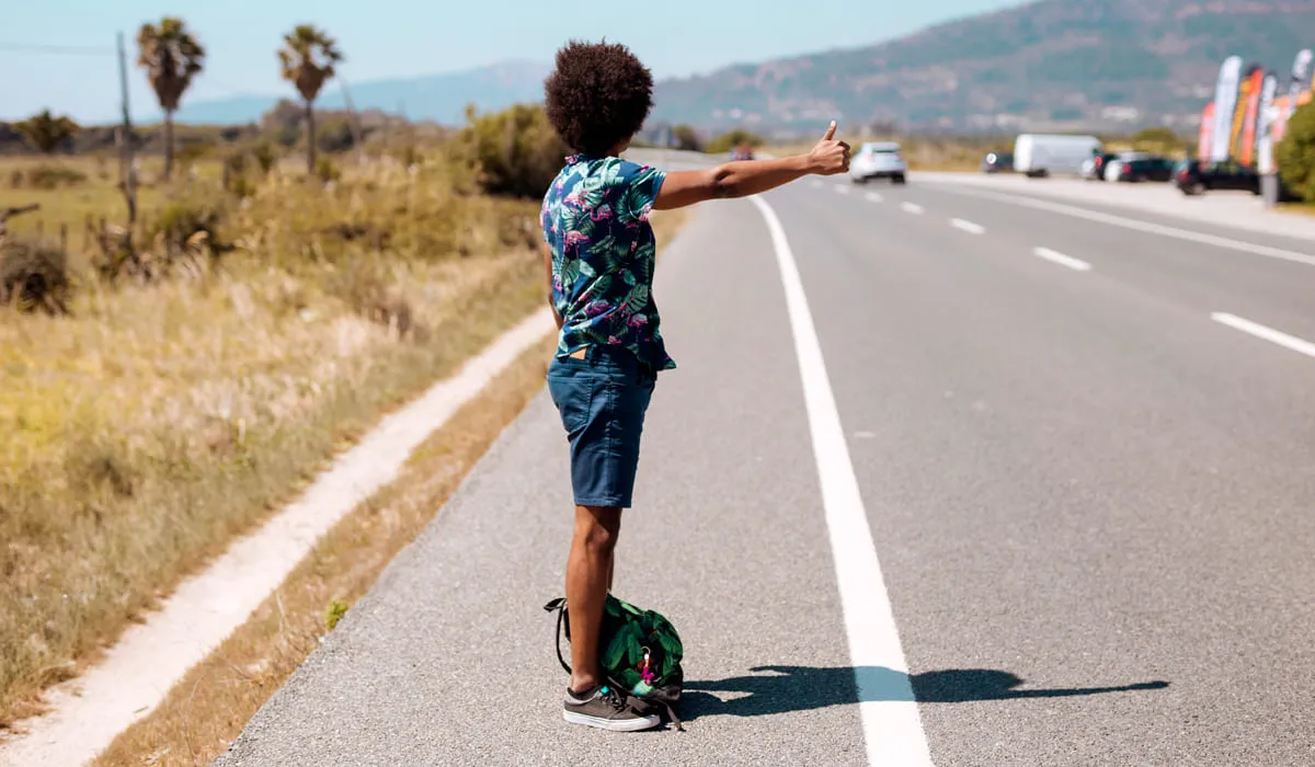 Man hitchhiking on the side of a road Man hitchhiking on the side of a road